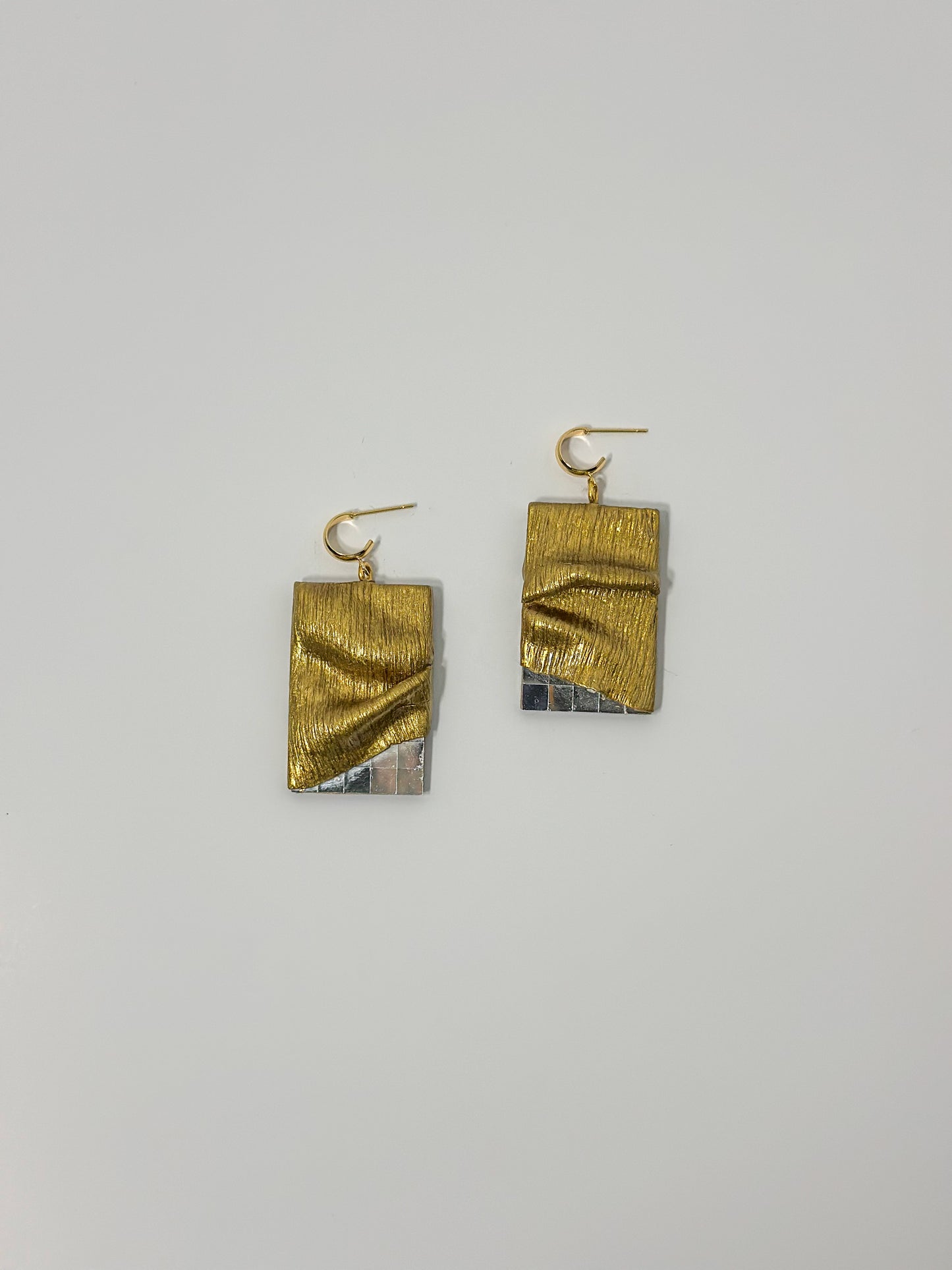 Top View: Crafted from gold clay, these hypoallergenic earrings feature intricate sculpting and textured detailing, draping elegantly over glass mirror pieces.