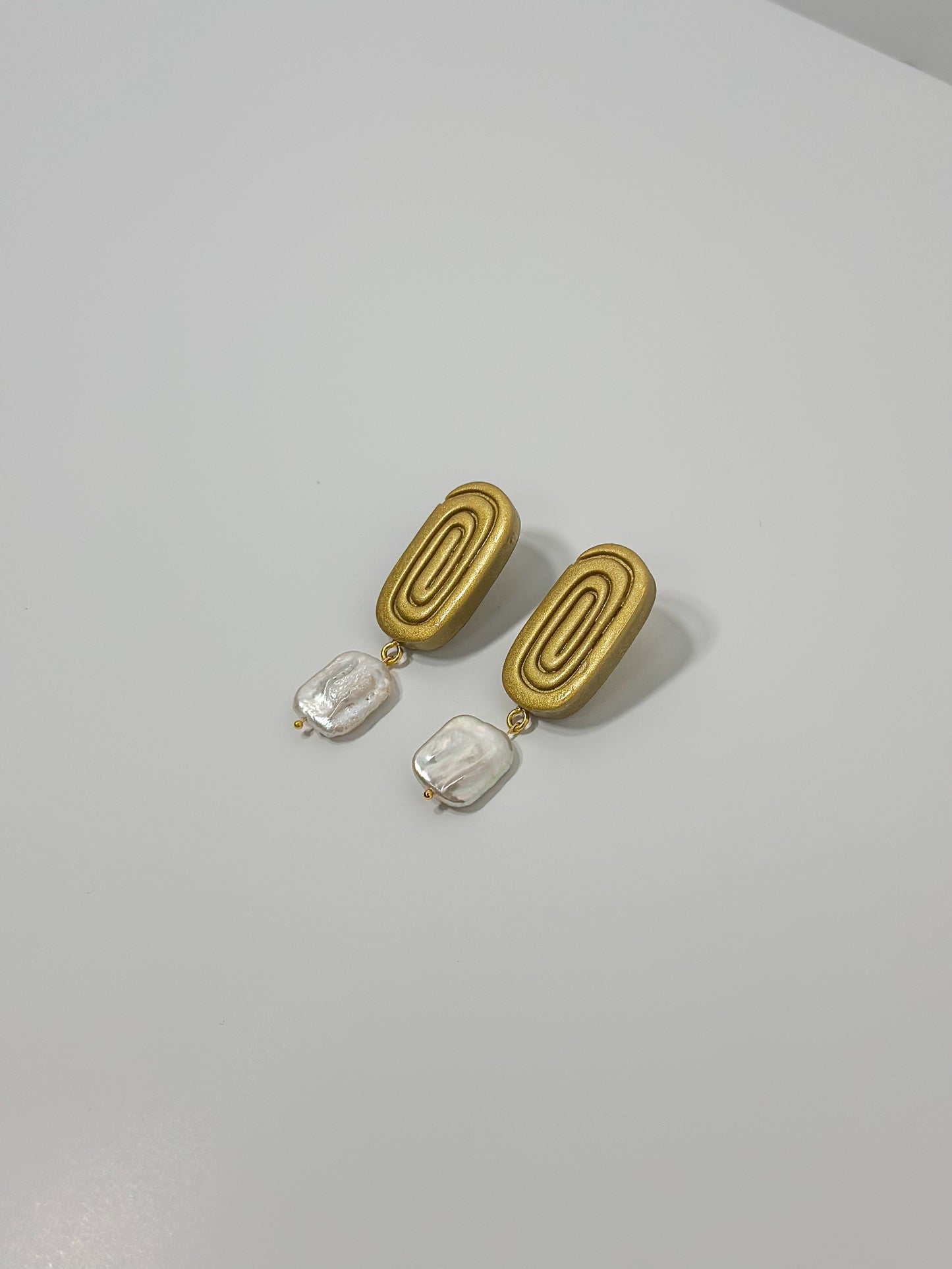 Handmade golden oval spiral earrings with a square baroque pearl. Elegant and unique, ideal for bridal jewelry.